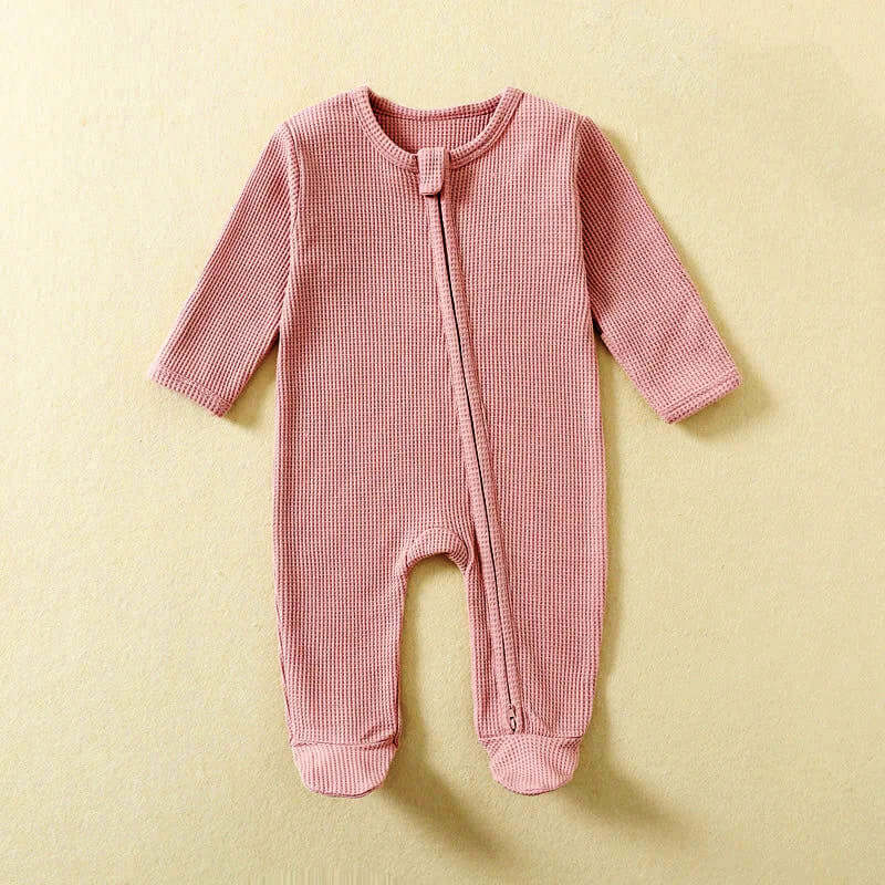 100% Organic Cotton Baby Romper in pastel pink, footed PJ's with zipper closure for quick changes, long sleeves, and soft breathable waffle fabric