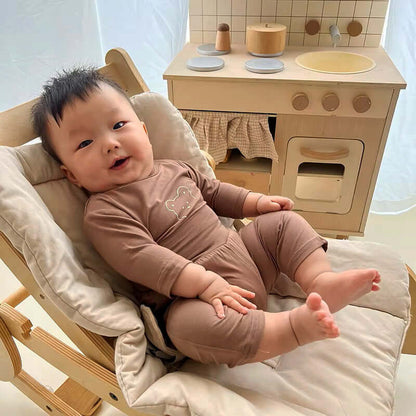 Cute baby in Snuggle Bear Pajamas lounging in a cozy chair, perfect for bedtime comfort.