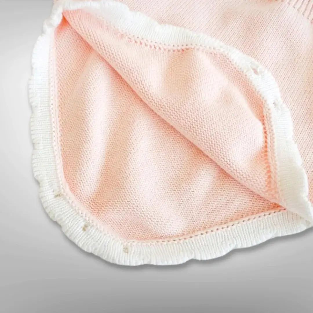 Soft blush knit fabric of Ballerina Dreams Romper with white ruffle trim, perfect for infants aged 3-24 months.