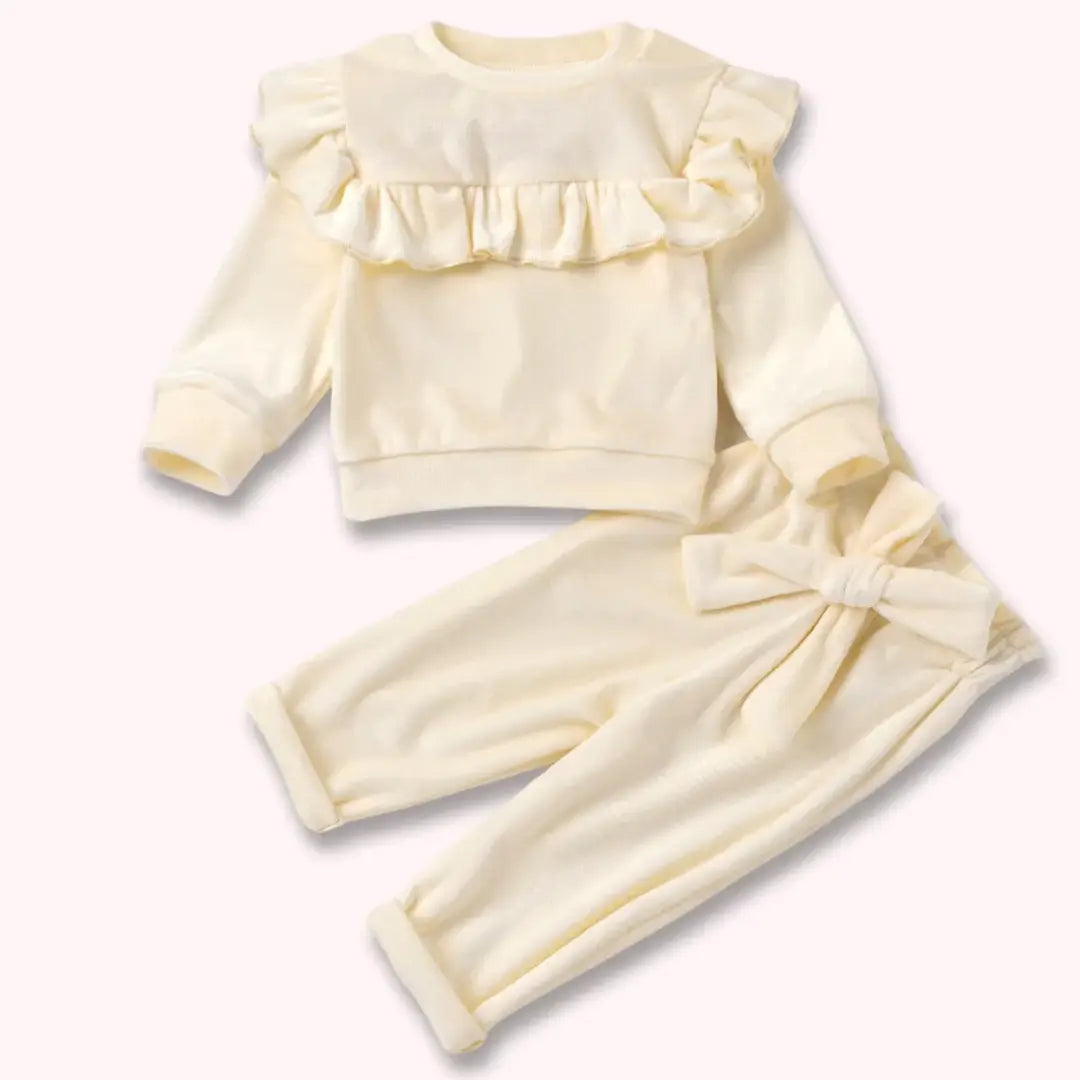 Blush & Snow Ruffle Velvet Baby Set with ruffle top and bow-tied pants in soft white, perfect for cozy elegance and special occasions.