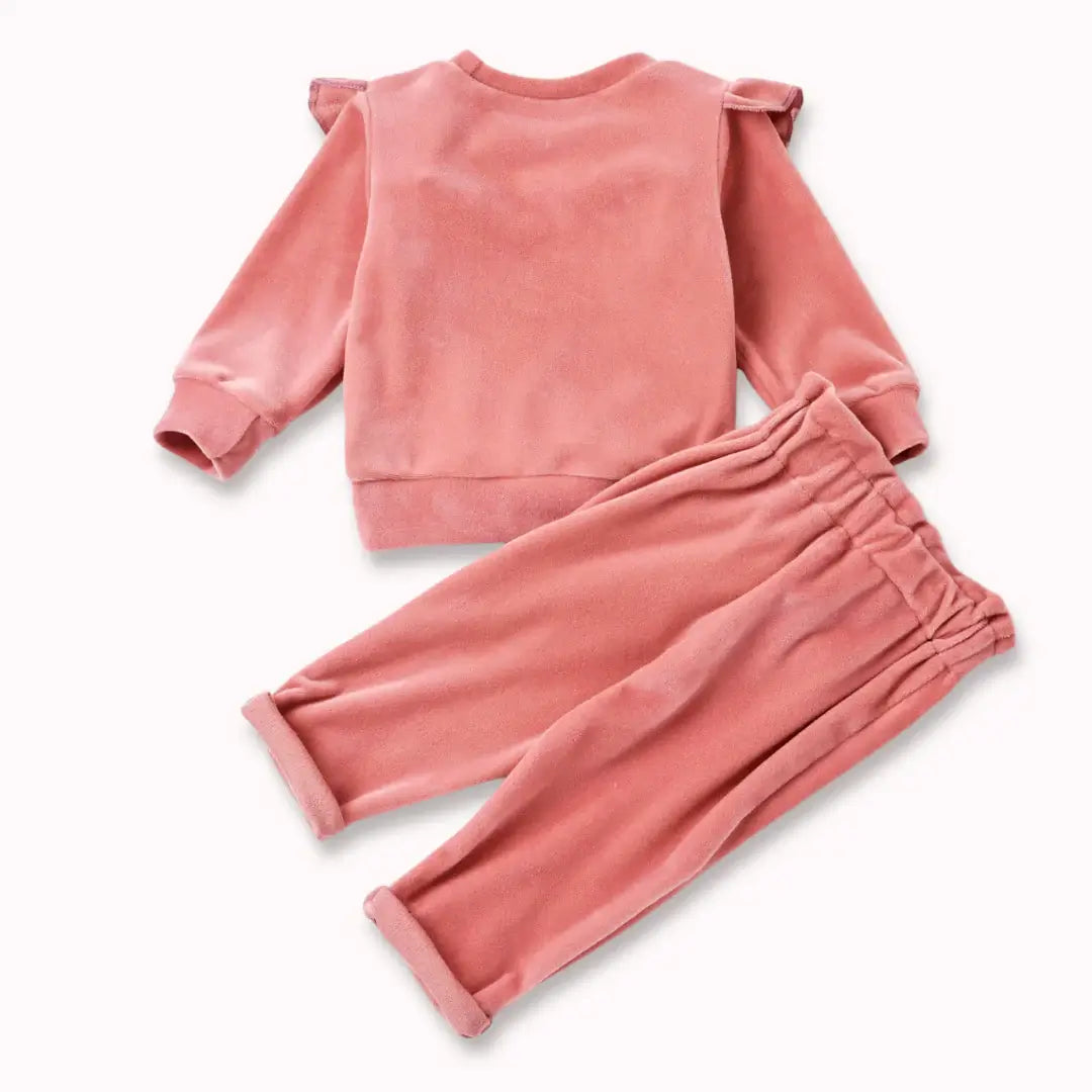 Blush velvet baby set with ruffle top and bow-tied pants, perfect for warmth and elegance in soft blush color.