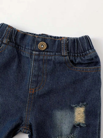 Distressed denim jeans for kids with stylish rips and elastic waistband, perfect for a boho chic outfit.