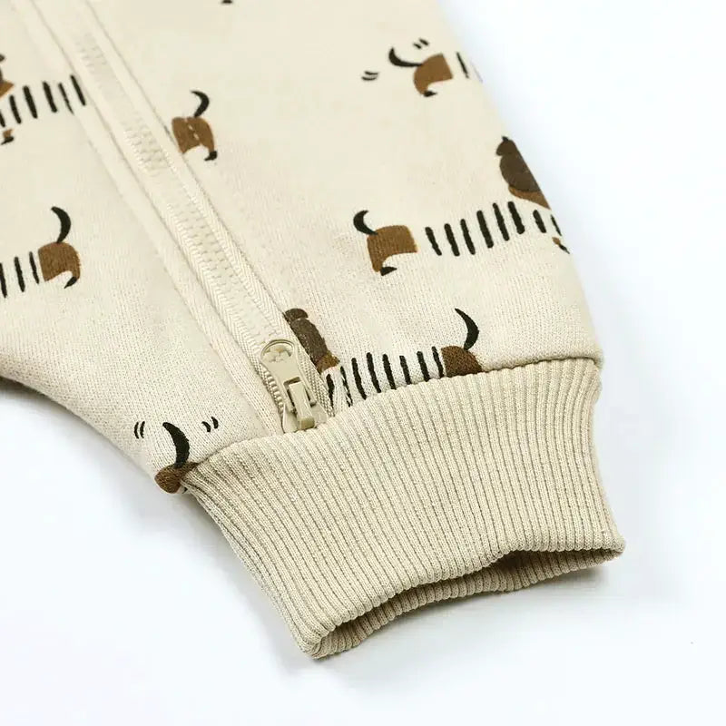 Close-up of the Dachshund Long Sleeve Hooded Romper showing cute dog pattern and cozy ribbed cuffs for little ones.