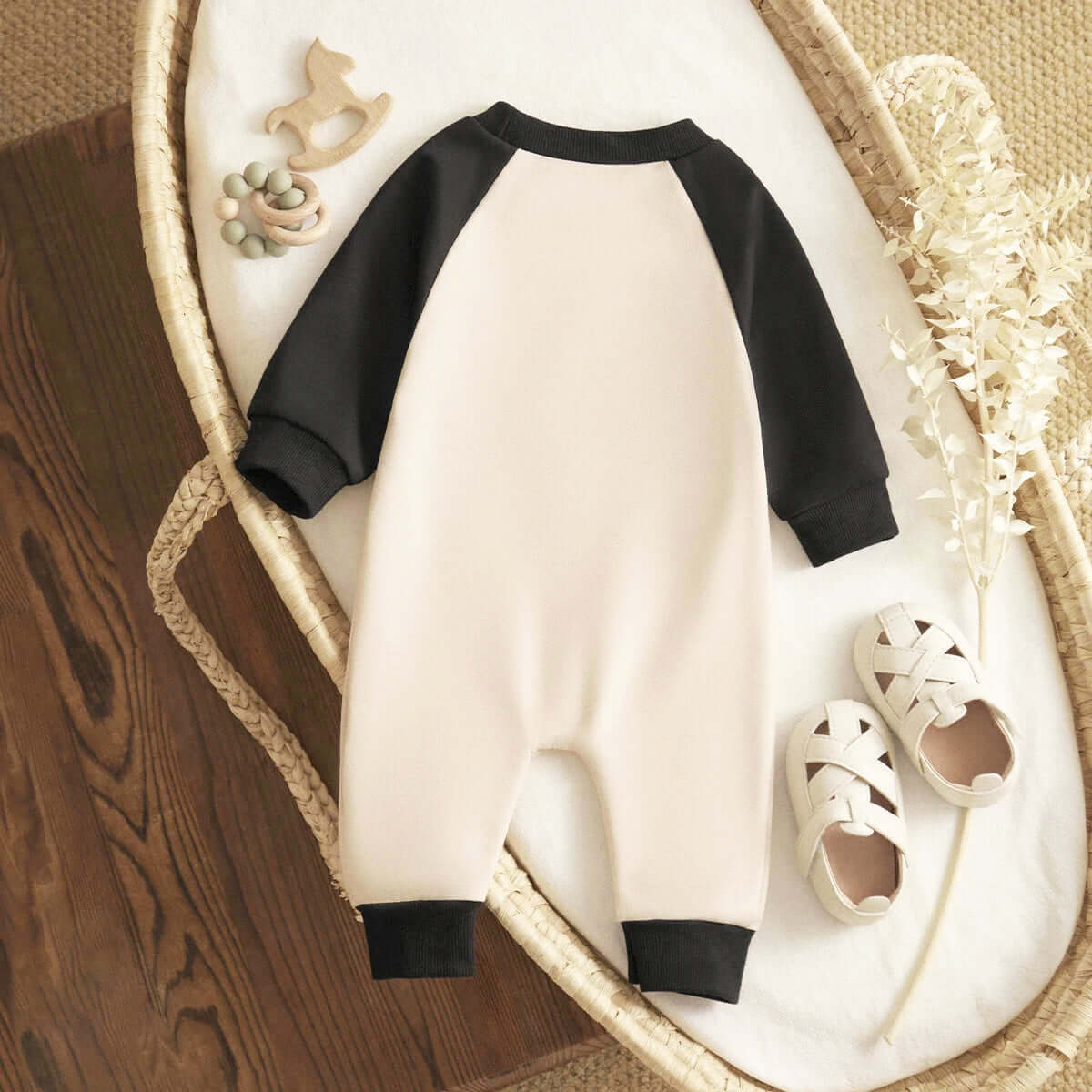 Cozy Hey Boo! Halloween Long Sleeve Romper in cream and black with playful accessories for infants (0-18M) in a cute nursery setting.