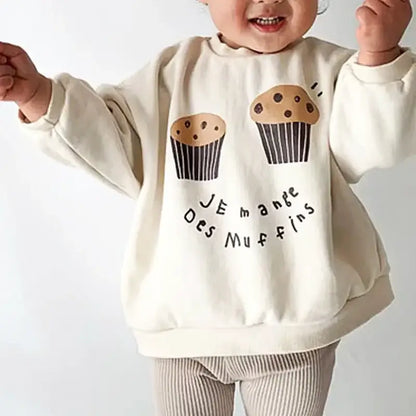 Cozy sweatshirt for kids with muffin print and French text "Je Mange Des Muffins". Perfect for ages 18M-6Y, playful design.