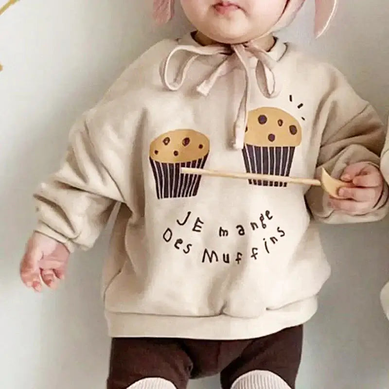 Toddler wearing Je Mange Des Muffin sweatshirt with cute muffin design, perfect for ages 18M-6Y, cozy and playful style.