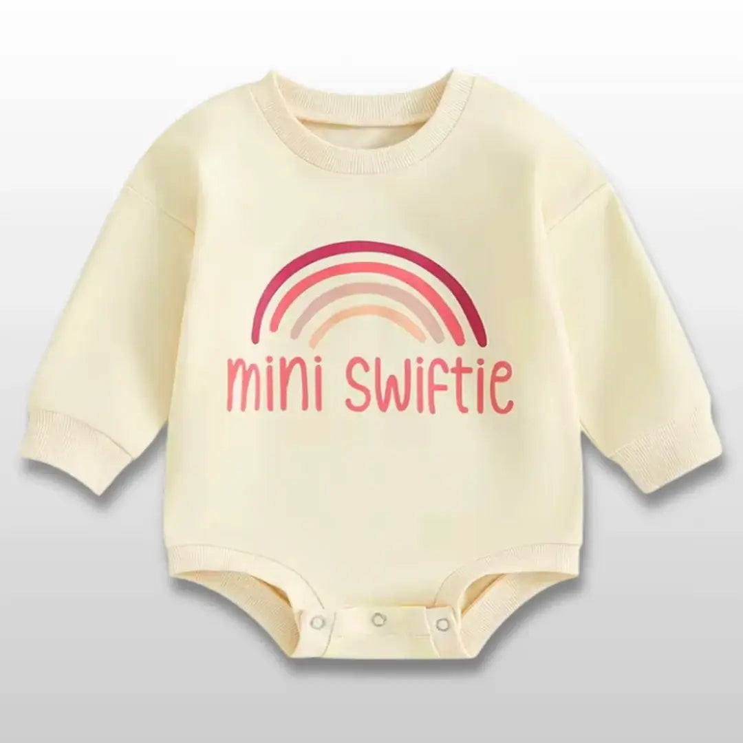 Yellow baby romper with "mini swiftie" text and rainbow design, perfect for little Swifties aged 0-18 months.