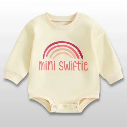 Yellow baby romper with "mini swiftie" text and rainbow design, perfect for little Swifties aged 0-18 months.