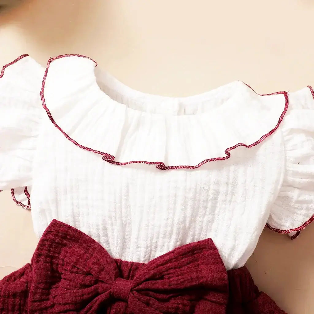 Elegant Milan Muse Butterfly Dress for baby girls aged 3-24 months with charming butterfly sleeves and a stylish maroon bow.