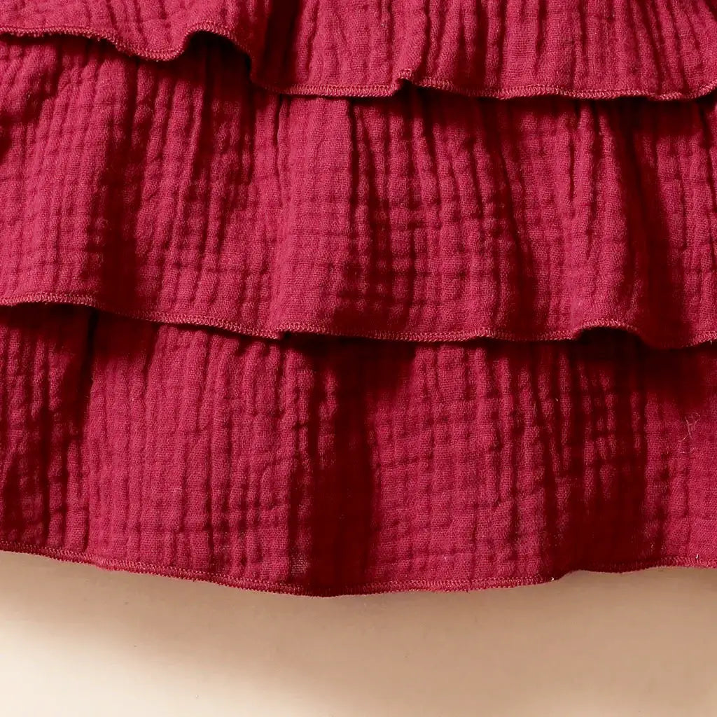 Close-up of burgundy fabric with ruffled texture, showcasing the Milan Muse Butterfly Dress for babies aged 3-24 months.