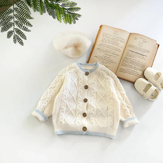 Cozy ivory cable knit baby cardigan with button-up front, perfect for layering. Nordic charm for little ones aged 3-36 months.