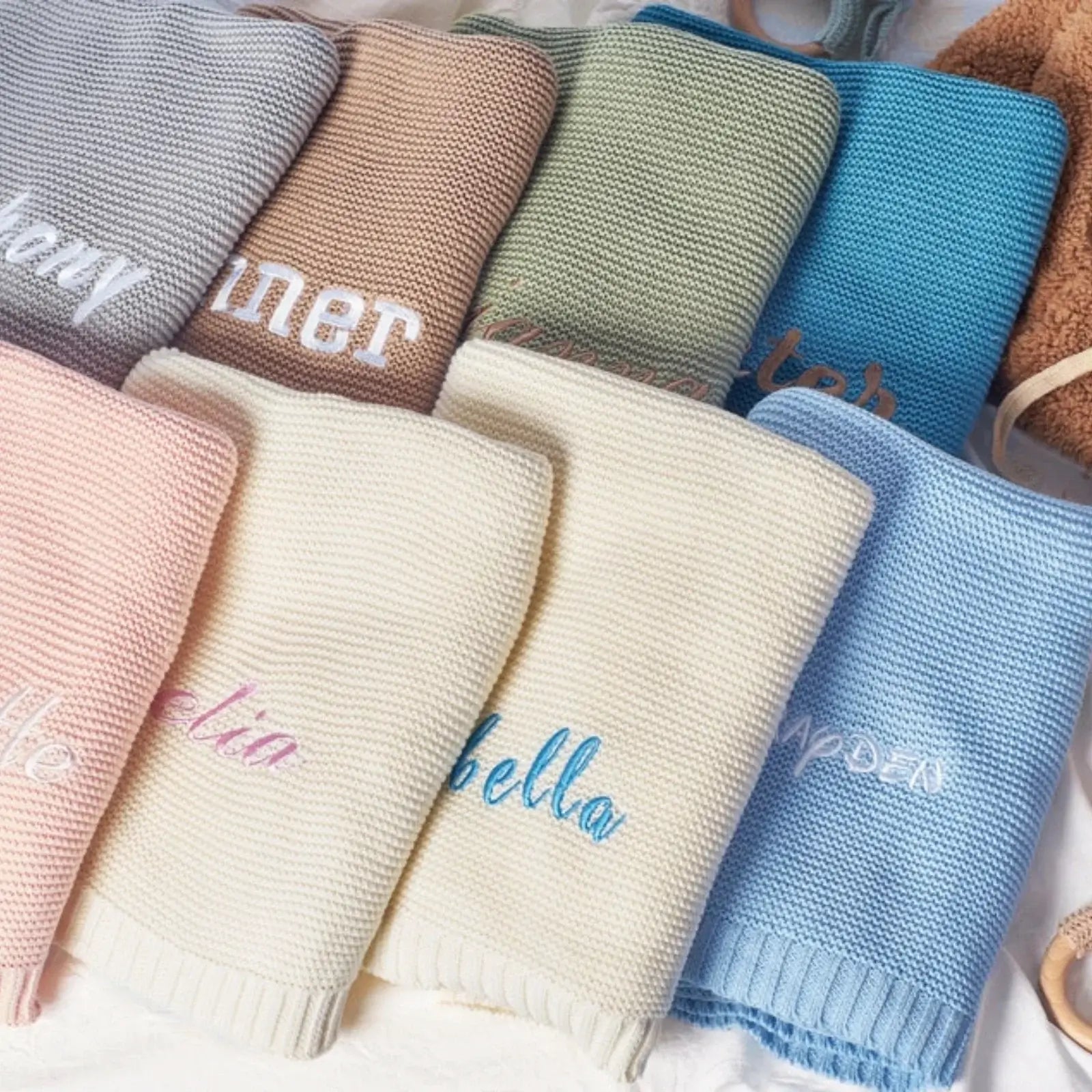 Personalized 100% cotton baby blankets in various colors, featuring unique embroidered names for a cozy touch.