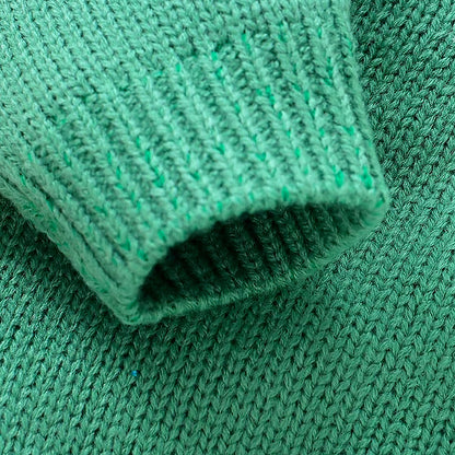 Close-up of green knit fabric texture from the Playful Pup Knit Romper, showcasing the soft and cozy material.