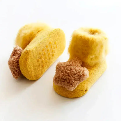 Ultra-soft yellow anti-slip baby socks for ages 6M-2T with fuzzy texture and star details, perfect for newborns and toddlers.