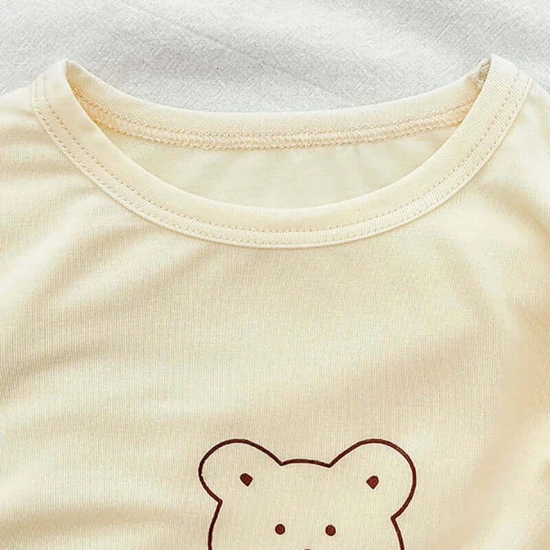 Snuggle Bear Pajamas soft stretchy top with playful bear print for babies and toddlers on a cozy background