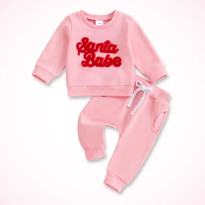 Festive "Santa Babe" red sweatshirt and pink joggers set for toddlers, perfect for holiday cheer and cozy family gatherings.