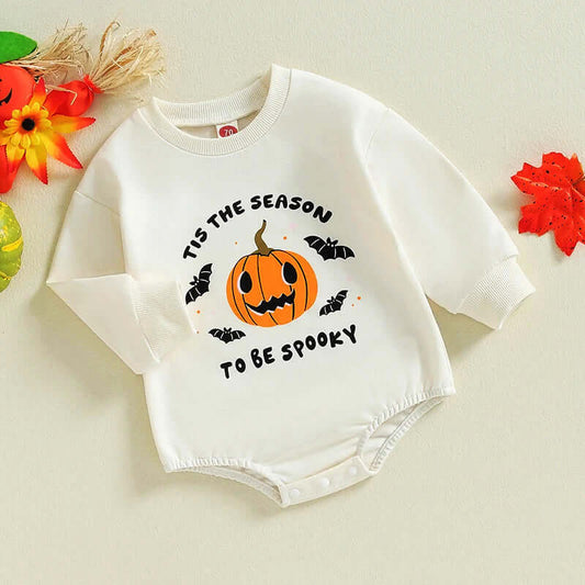 Adorable long sleeve Pumpkin & Bats Halloween romper for babies with "Tis the season to be spooky" print, surrounded by fall leaves.