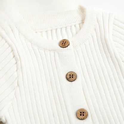 Cozy knitted cotton jumpsuit with wooden buttons, perfect for baby's comfort and cuteness.