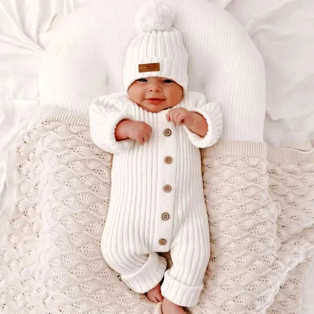 Baby wearing a Sweet Dreams Knitted Cotton Jumpsuit in white, cozy and soft, perfect for comfort and cuteness from 3-24 months.