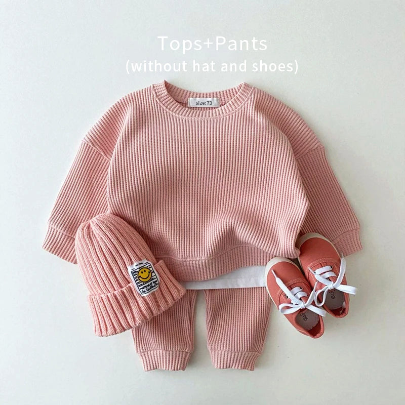 Trendy pink waffle sweatshirt and pants toddler outfit, perfect for stylish and cozy playtime.