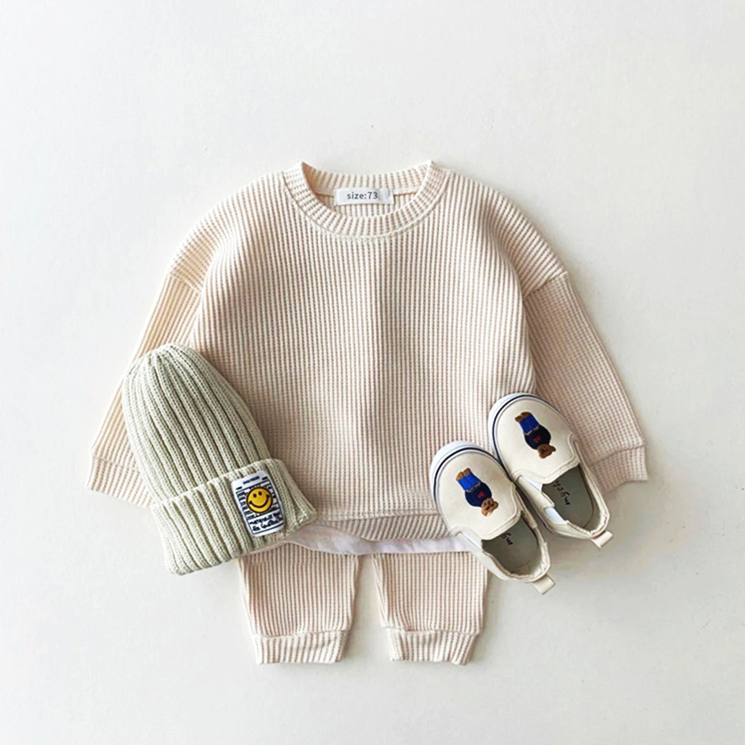 Trendy toddler cotton-waffle sweatshirt and pants set with beanie and shoes, perfect for stylish playtime.