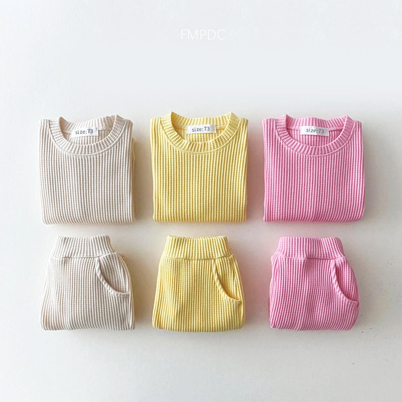 Trendy toddler cotton-waffle sweatshirt and pants set in beige, yellow, and pink, perfect for stylish comfort.