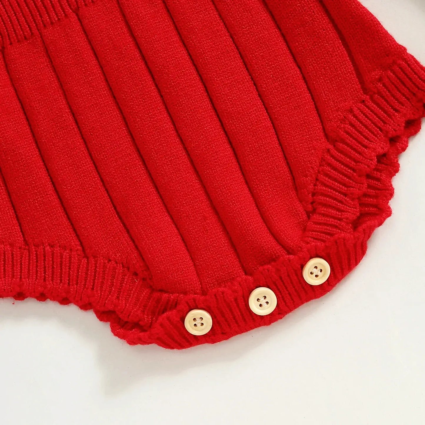 Red knit romper with ruffled edges and cute buttons, perfect for baby winter festivities and fall snuggles.